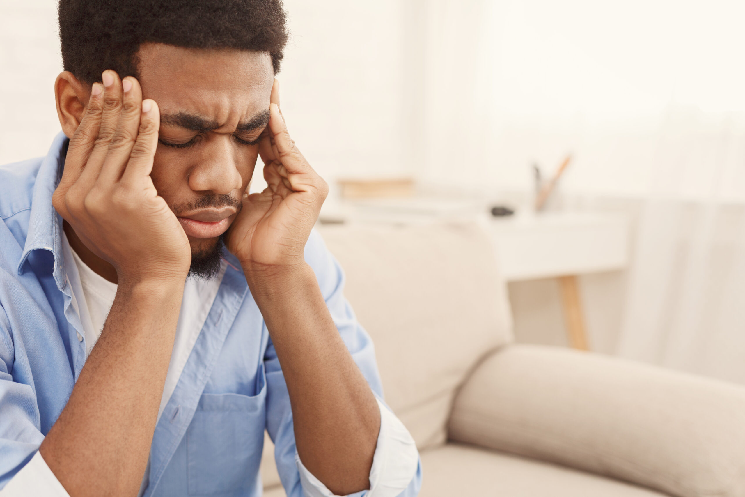 Exhausting migraine. Young african-american man suffering from headache at home, copy space